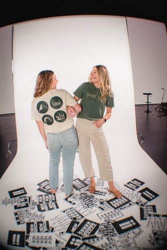 A group laughs together while modeling shirts